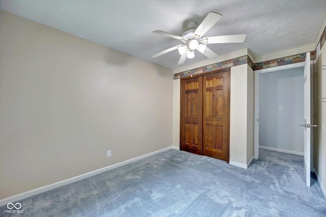 unfurnished bedroom featuring carpet, ceiling fan, a textured ceiling, and a closet