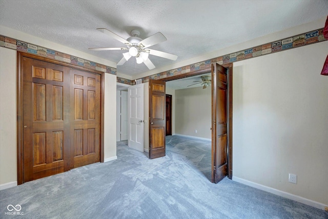 unfurnished bedroom featuring carpet flooring, ceiling fan, a closet, and a textured ceiling