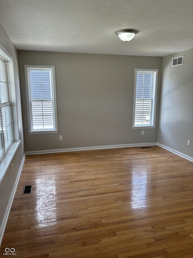 unfurnished room featuring a textured ceiling and hardwood / wood-style flooring