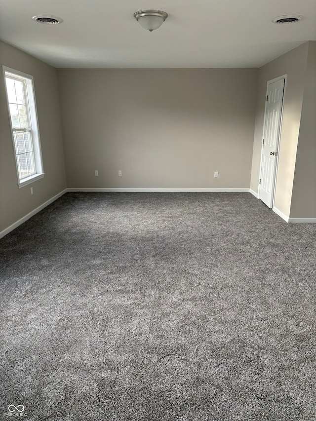 spare room featuring dark colored carpet