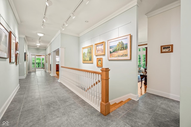 corridor featuring an upstairs landing, baseboards, and ornamental molding