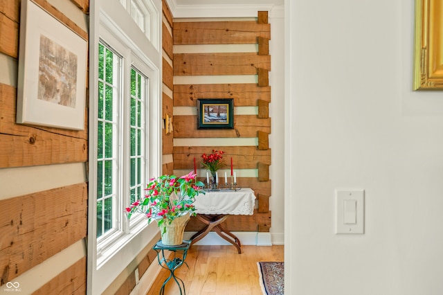 hall with crown molding and light wood-type flooring