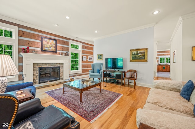 living room with a fireplace, a healthy amount of sunlight, and light hardwood / wood-style flooring