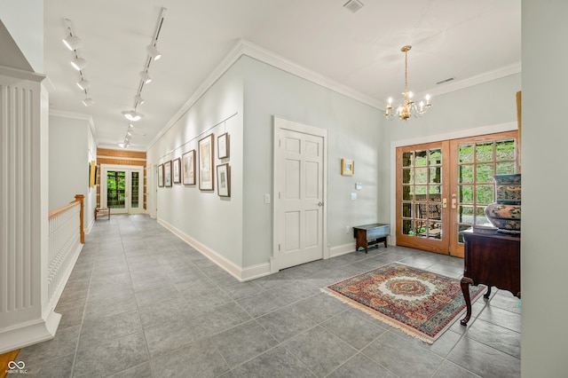 foyer with tile patterned flooring, a notable chandelier, french doors, and crown molding