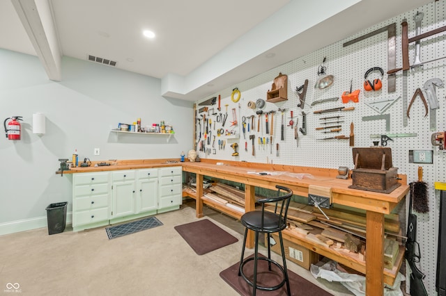 bar featuring green cabinetry and a workshop area