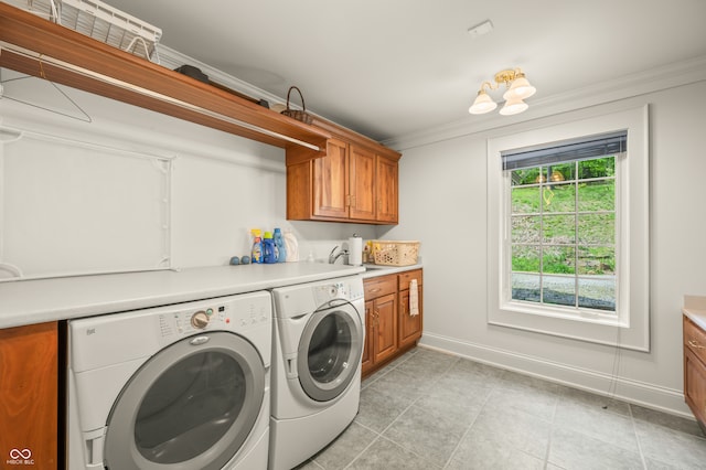 laundry area with independent washer and dryer, cabinets, ornamental molding, and light tile patterned floors