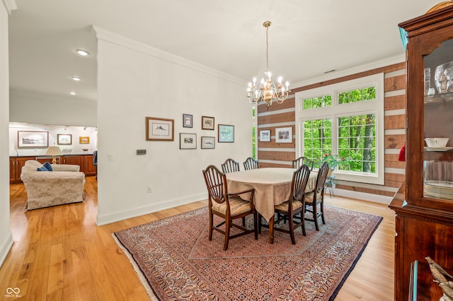 dining room featuring light hardwood / wood-style floors, crown molding, and a chandelier