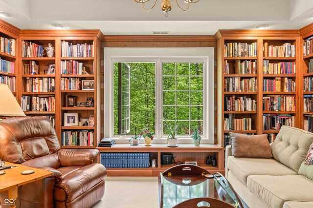 living area featuring a chandelier and carpet