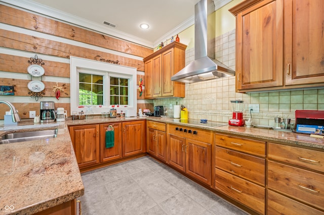 kitchen featuring sink, light stone counters, backsplash, light tile patterned floors, and wall chimney exhaust hood