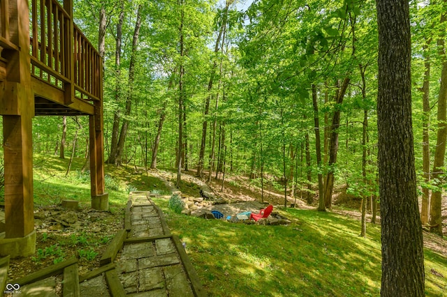 view of yard with a wooden deck and a wooded view