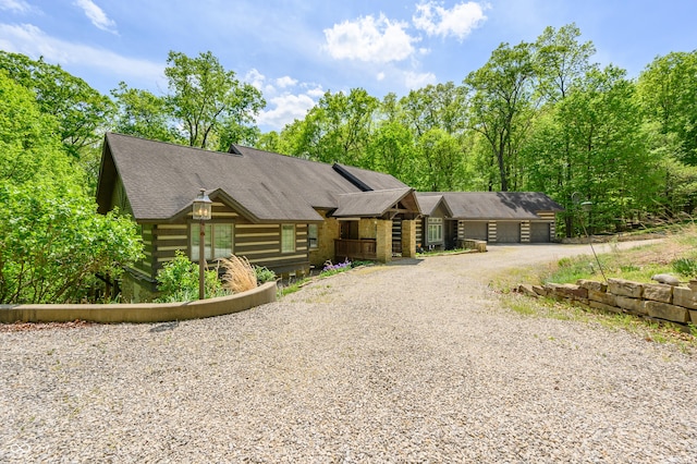 view of front facade with driveway and a shingled roof