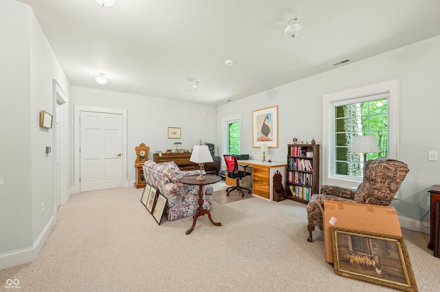 interior space with light colored carpet, a healthy amount of sunlight, visible vents, and baseboards