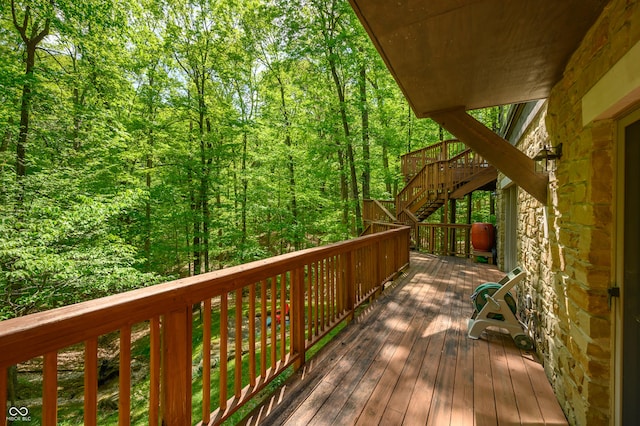 deck with a view of trees and stairs