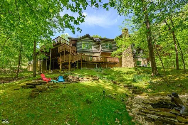 back of house featuring a wooden deck and a yard