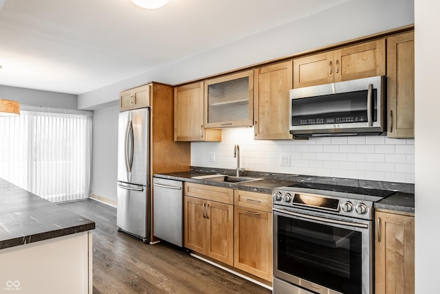 kitchen featuring appliances with stainless steel finishes, dark hardwood / wood-style flooring, sink, and decorative backsplash