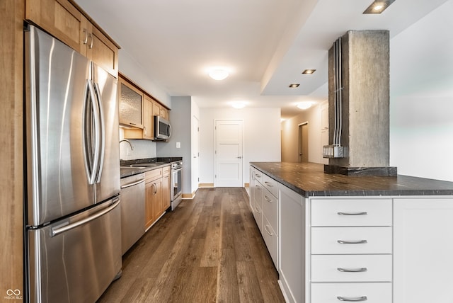 kitchen featuring sink, appliances with stainless steel finishes, dark hardwood / wood-style flooring, kitchen peninsula, and white cabinets