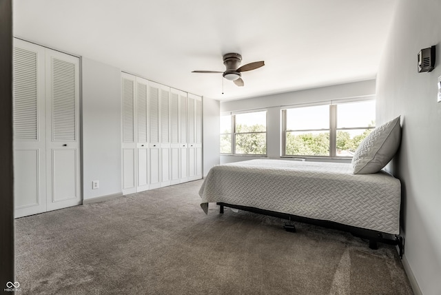 carpeted bedroom with two closets and ceiling fan