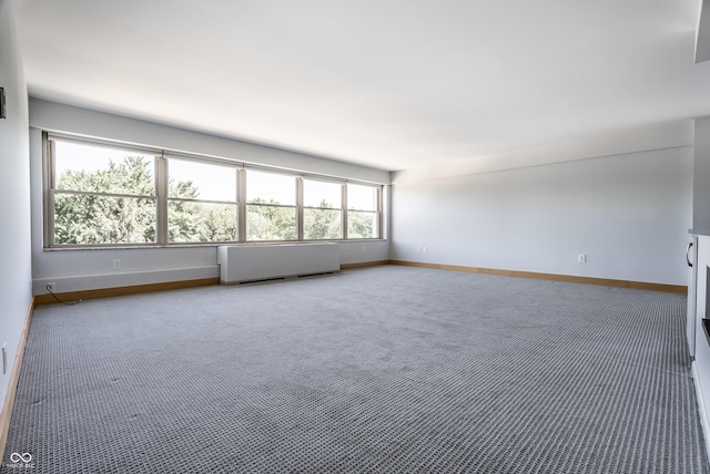 carpeted empty room featuring radiator heating unit