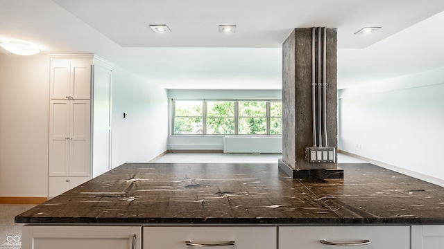 kitchen with dark stone counters and white cabinets