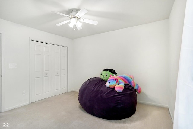 bedroom featuring ceiling fan, light carpet, and a closet