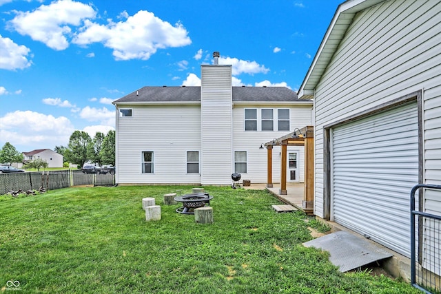 back of property featuring an outdoor fire pit and a yard