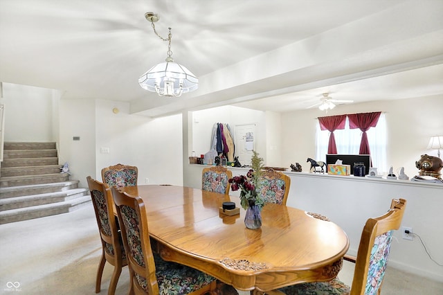 dining area with light carpet and ceiling fan with notable chandelier