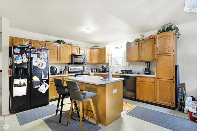 kitchen with black appliances, sink, a kitchen breakfast bar, and a center island