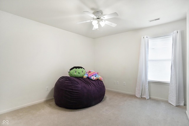 living area with ceiling fan and light colored carpet