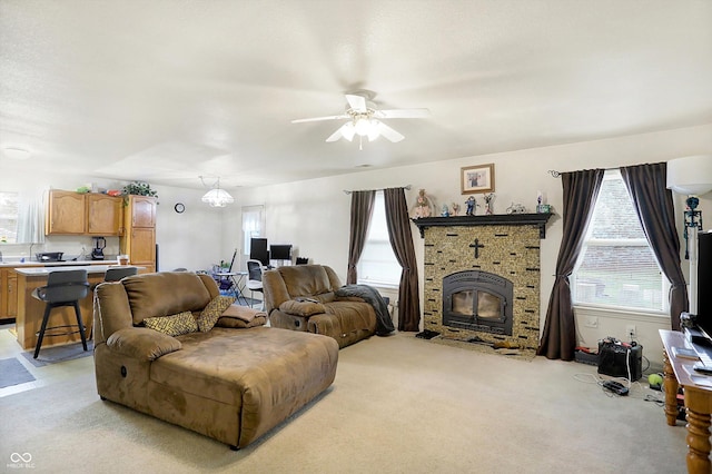 carpeted living room featuring ceiling fan and a wood stove