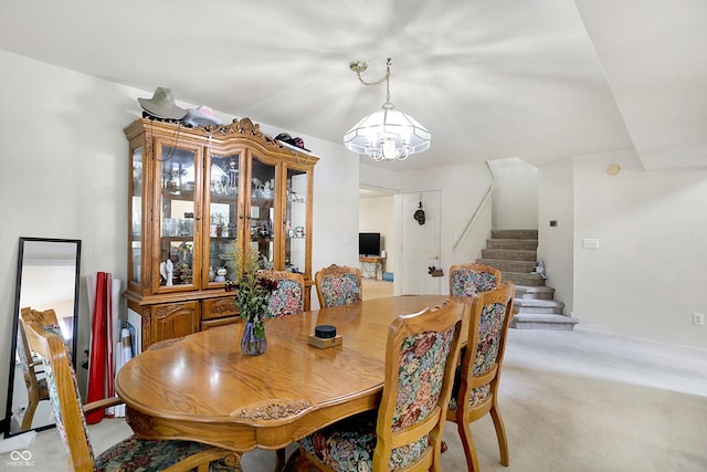 dining space with light colored carpet and a chandelier