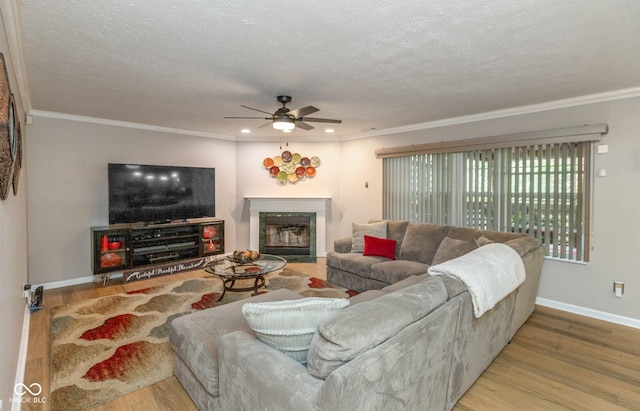 living room featuring a textured ceiling, hardwood / wood-style floors, and crown molding