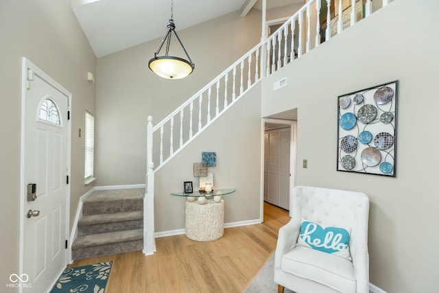 foyer with high vaulted ceiling and hardwood / wood-style flooring