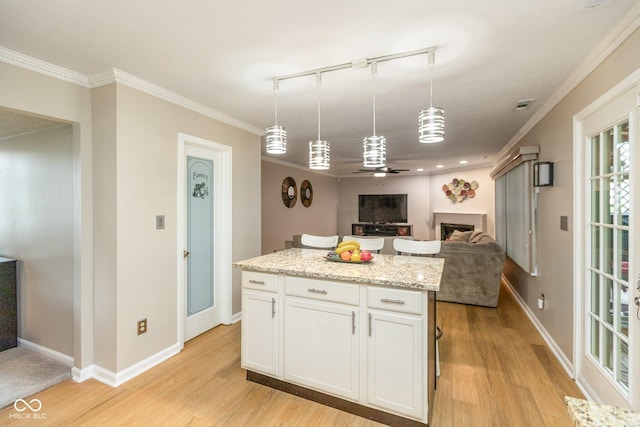 kitchen with light stone countertops, hanging light fixtures, track lighting, white cabinets, and ceiling fan