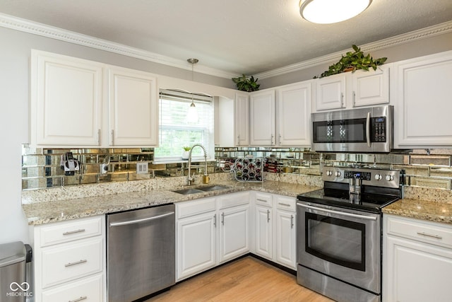 kitchen with stainless steel appliances, white cabinets, sink, and backsplash