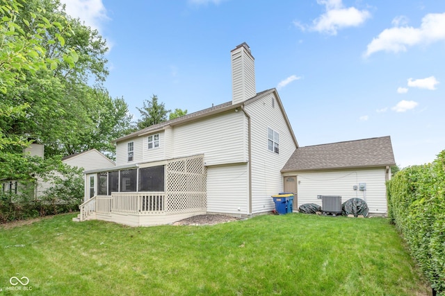 back of house with central air condition unit, a yard, and a sunroom