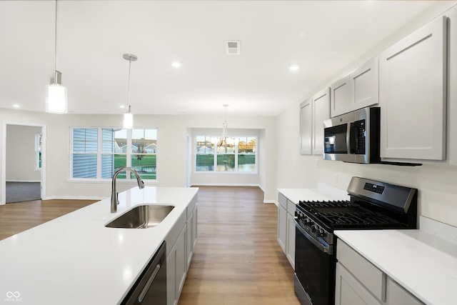 kitchen featuring hanging light fixtures, a notable chandelier, sink, and stainless steel appliances