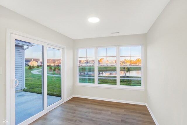 unfurnished sunroom featuring a water view