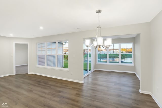 unfurnished dining area featuring dark hardwood / wood-style floors and a notable chandelier