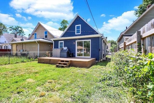 rear view of property with a lawn and a wooden deck