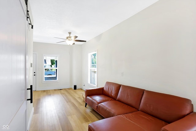 living room with light hardwood / wood-style floors and ceiling fan