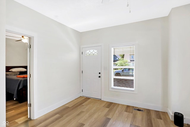 foyer entrance with ceiling fan and light hardwood / wood-style floors