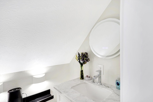 bathroom featuring a textured ceiling and vanity