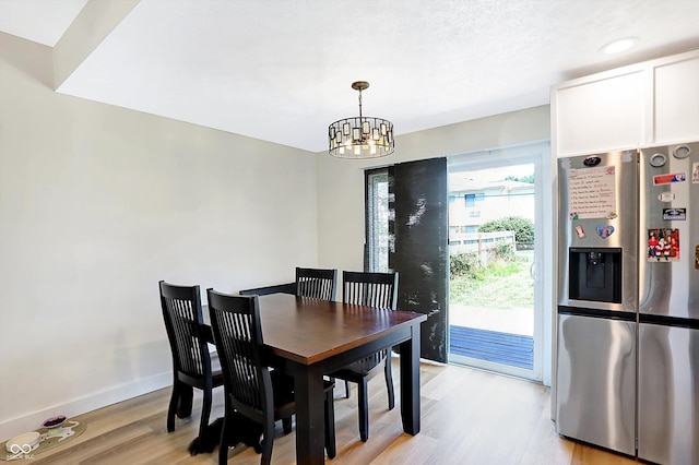 dining area featuring a notable chandelier and light wood-type flooring