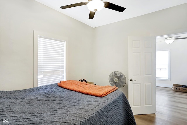 bedroom featuring hardwood / wood-style floors, ceiling fan, and vaulted ceiling