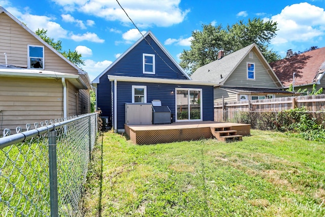 back of property featuring a lawn and a wooden deck