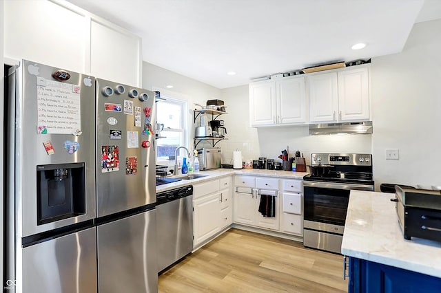 kitchen featuring sink, stainless steel appliances, light stone counters, light hardwood / wood-style flooring, and white cabinets