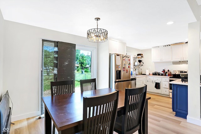 dining space featuring light hardwood / wood-style flooring and a chandelier