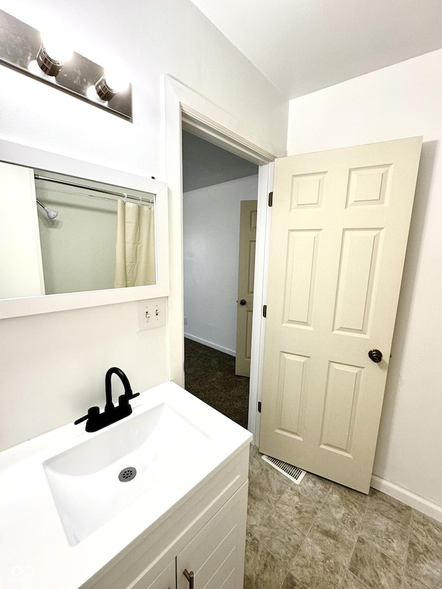 full bathroom with baseboards, visible vents, and vanity