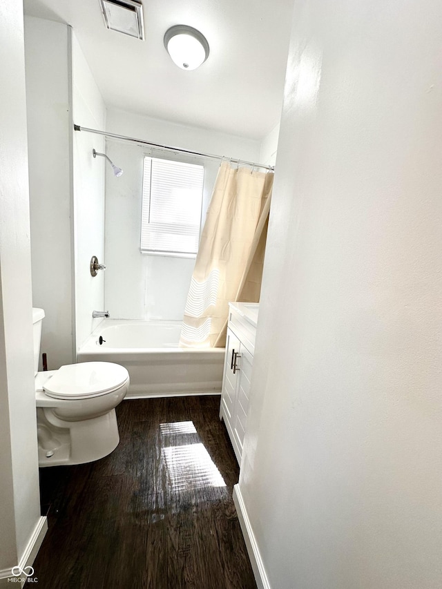 full bathroom featuring toilet, wood finished floors, vanity, visible vents, and shower / bathtub combination with curtain