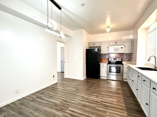 kitchen with dark hardwood / wood-style flooring, black fridge, sink, and electric stove